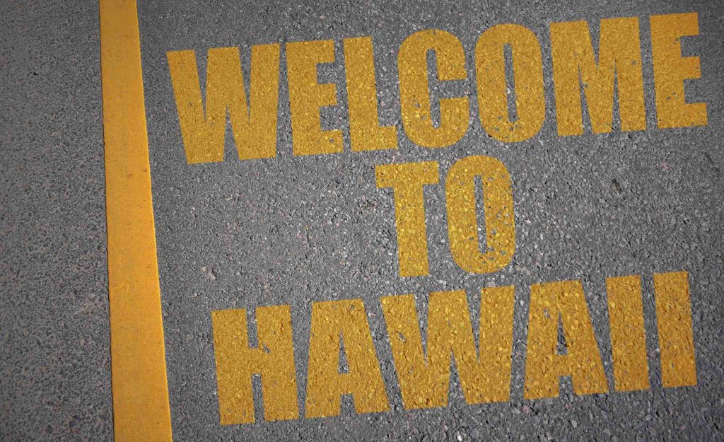 asphalt road with text welcome to hawaii near yellow line. concept