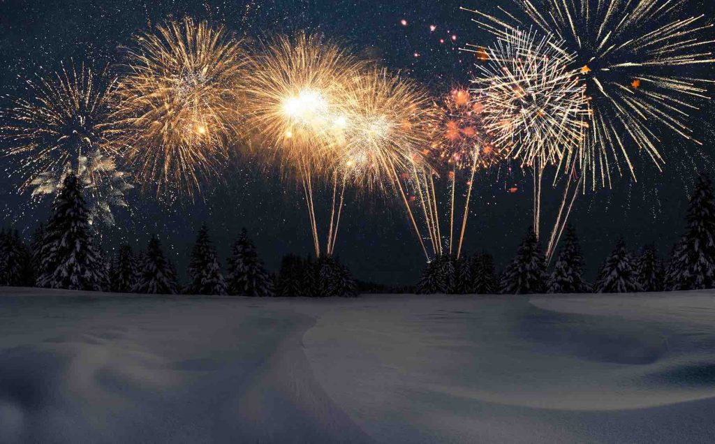 Amazing winter with snow, forest and starry sky with fireworks at night. New Year's and Christmas night with golden fireworks, creative idea. New Year 2024 party on the nature, card